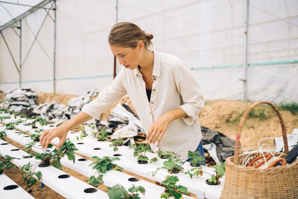 Woman in a beige shirt gardening.